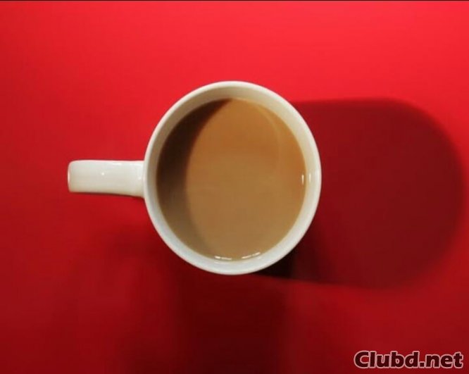 Mug with tea or coffee on a red table - picture