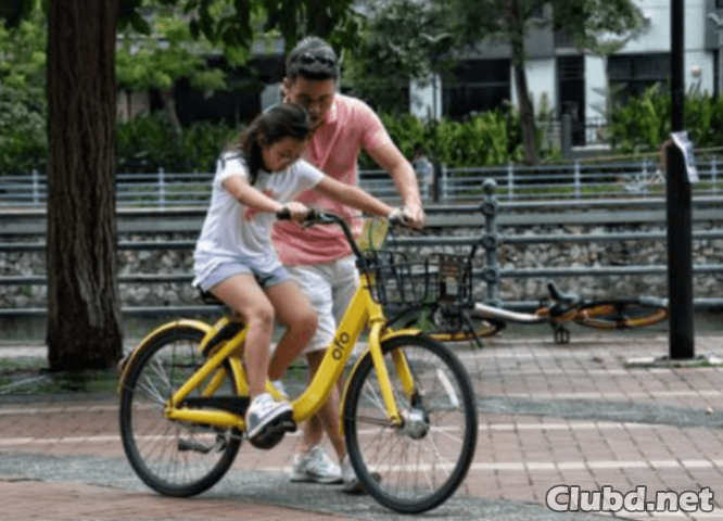 Отец учит дочь ездить на велосипеде - картинка