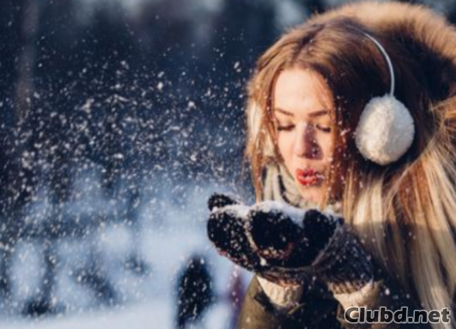 Chica soplando en la nieve en las manos - imagen